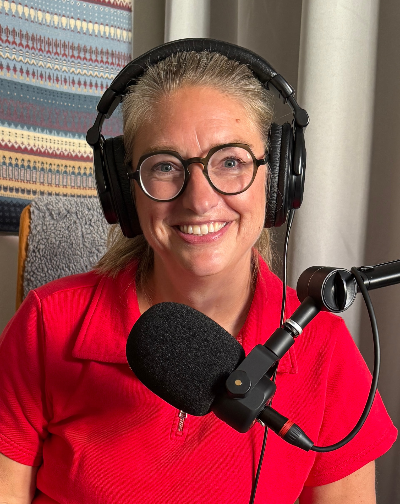 Annika Telléus i poddstudion med hörlurar och mikrofon