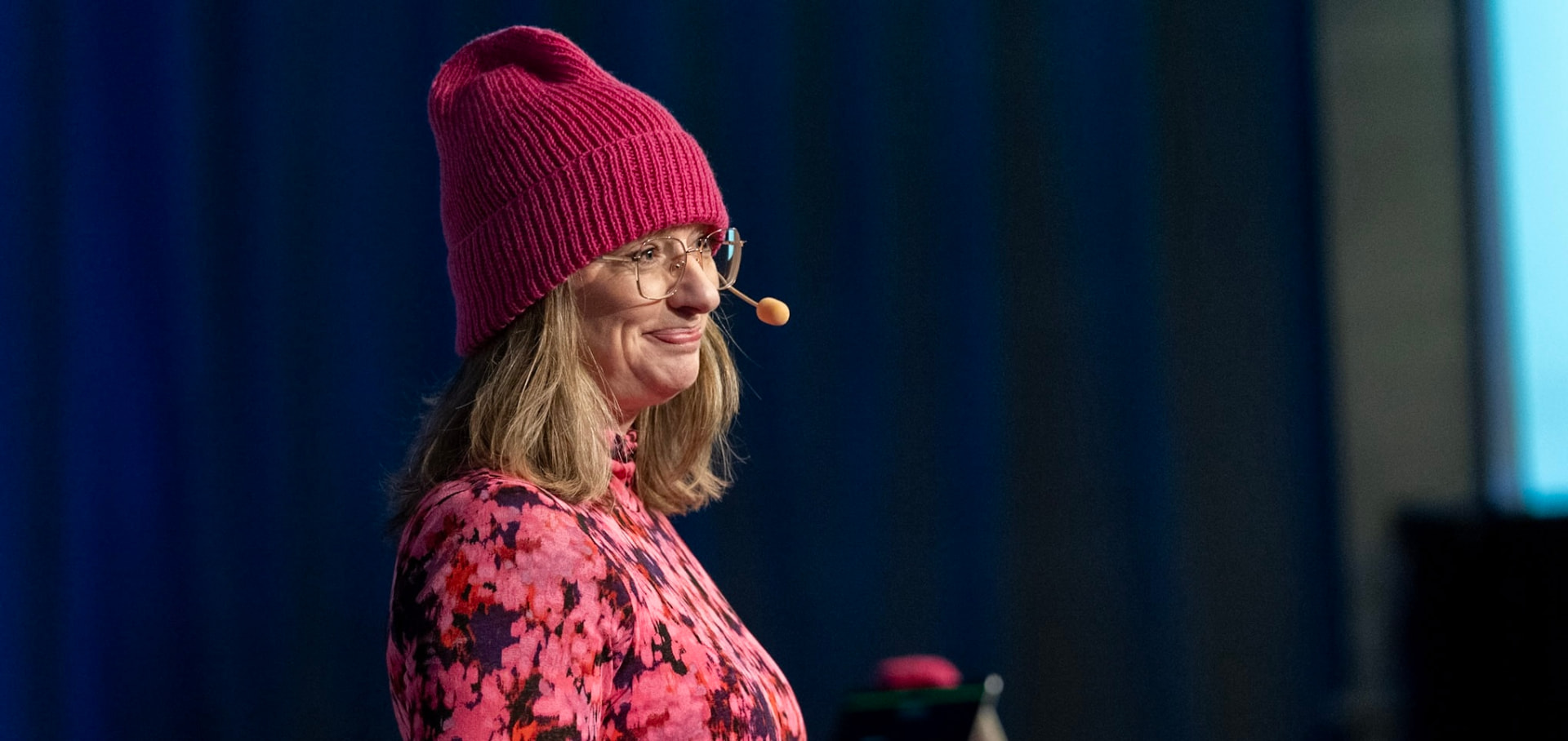 Annika Telléus wearing a cerise listening beanie on stage